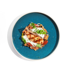 Healthy food - baked salmon steak with tomato salad and white sauce. Roast salmon with vegetables on contemporary plate in asian style. Restaurant dish - salmon filet with hard shadow.