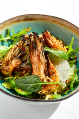 Green salad with grilled prawns and vegetables. Healthy food in restaurant menu. Shrimp with salad mix and peanuts - delicious dish for keto diet. Restaurant dish isolated on white background.