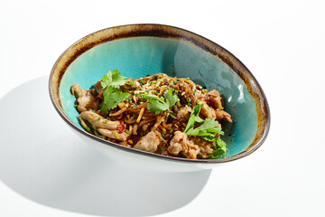 Japanese soba with chicken cooked on wok in asian style on white background. Noodle with chicken in ceramic bowl. Indonesian wok with soba noodles. Spicy thai dish with meat and udon.