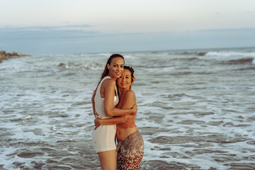 Lesbian couple hugging on the beach  