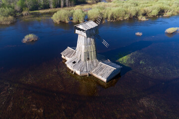 Flooded wooden windmill on the Sorot river on a sunny May day. The Loskovitsy (Loskovskoe). Pskov...