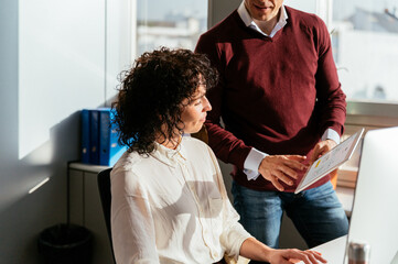 Happy colleague couple using computer in office desk