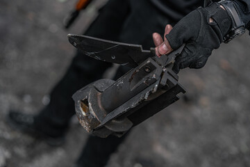 Close up of ukrainian soldier holding piece of bomb in hand