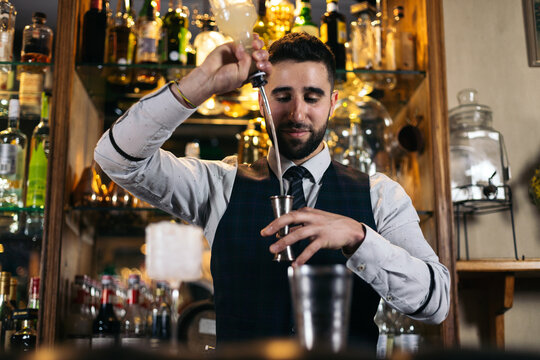 Professional young bartender preparing a cocktail