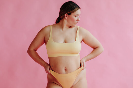 Confident curvy woman portrait pink background - Body positivity