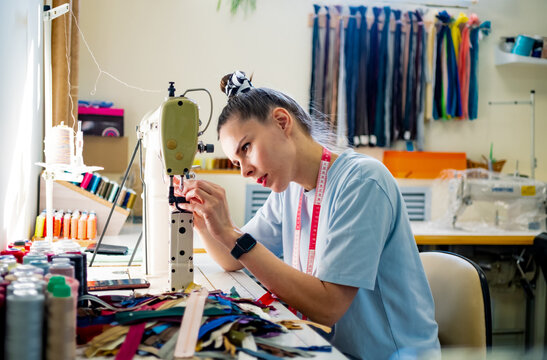 female entrepreneur sewing in her tailor studio 