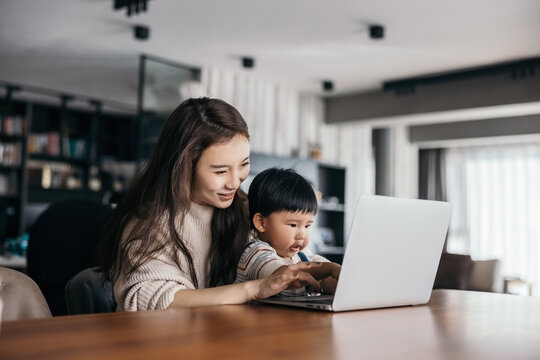 Asian little baby boy using laptop with his mom