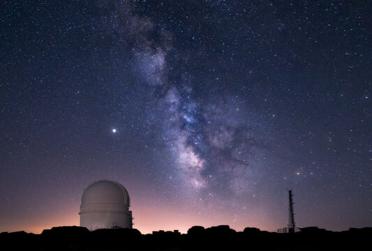 Milky way over an astronomical observatory telescope