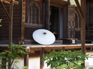 寺の建物の縁側にある番傘