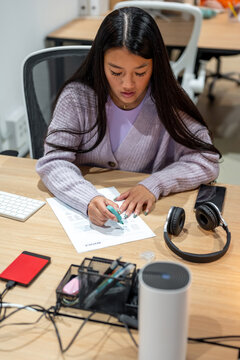 Focused woman highlighting main points in report