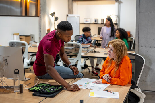 Multiracial colleagues doing paperwork in workspace