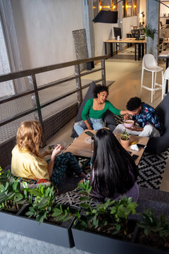 Hungry diverse friends having lunch together at coworking space