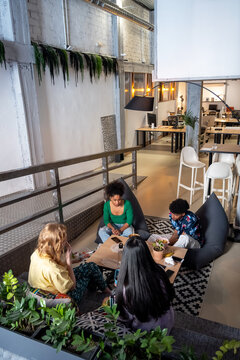 Hungry diverse friends having lunch together at coworking space