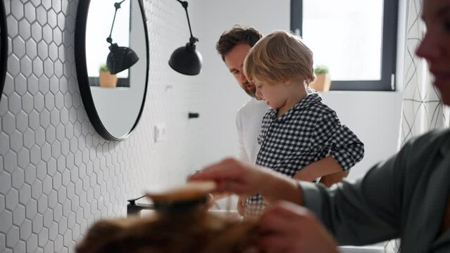 Young family together in bathroom, morning routine concept.