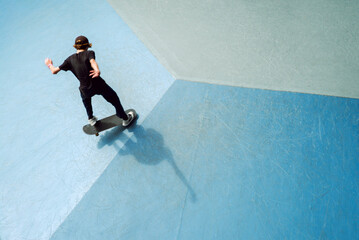 Teenage boy riding a skateboard in a skate park