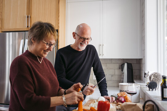 Mature couple making meal together.