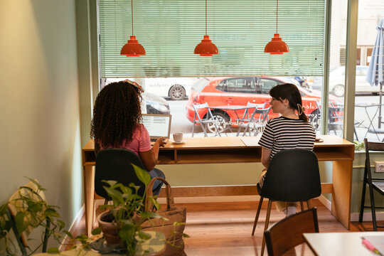 Diverse women studying together in coffee shop