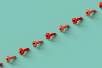 a row of pink screws on a blue background with copy space