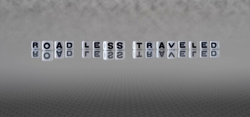 road less traveled word or concept represented by black and white letter cubes on a grey horizon...