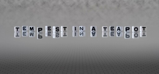 tempest in a teapot word or concept represented by black and white letter cubes on a grey horizon...