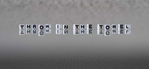 throw in the towel word or concept represented by black and white letter cubes on a grey horizon...