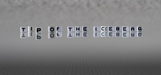 tip of the iceberg word or concept represented by black and white letter cubes on a grey horizon...