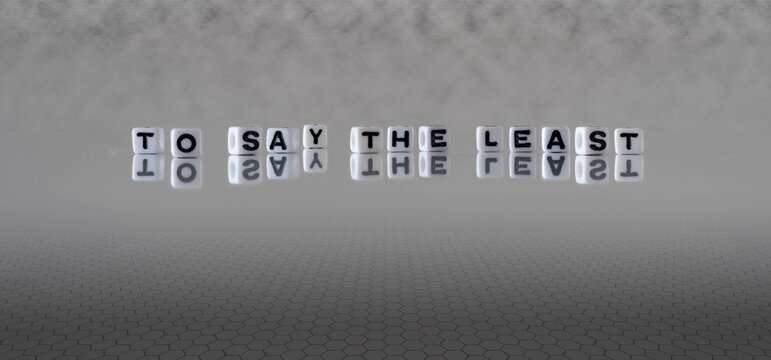 to say the least word or concept represented by black and white letter cubes on a grey horizon background stretching to infinity