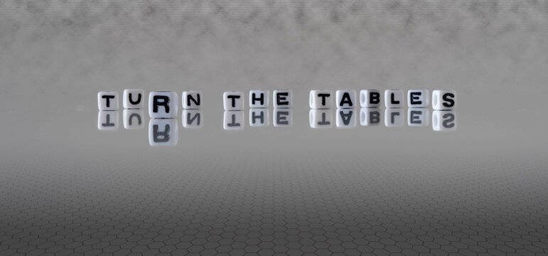 turn the tables word or concept represented by black and white letter cubes on a grey horizon background stretching to infinity