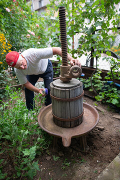 Mature Man Cleaning Wooden Wine Press