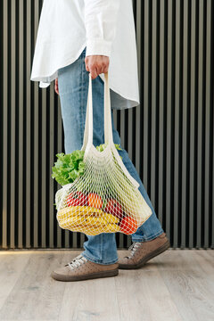 Crop woman carrying bag with groceries
