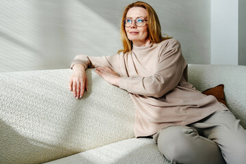 Dreamy woman resting on sofa