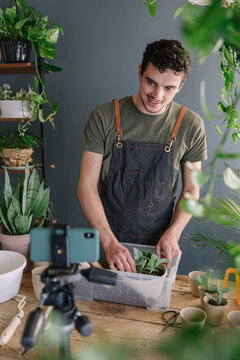 Man Repotting Pothos In Bigger Vase And Filming The Process