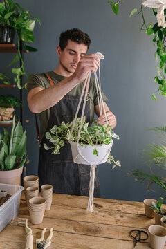 Man Preparing To Hang Plants From The Ceiling Surrounded By Nature 