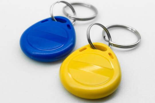 RFID tag key chain. Plastic cloned non-contact electronic radio key for intercom. NFC tag. Ukrain flag colors. Selective focus - Powered by Adobe