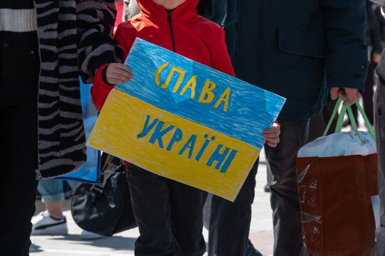 Child holding Ukrainian flag "Glory to Ukraine"