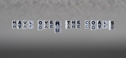 haul over the coals word or concept represented by black and white letter cubes on a grey horizon...