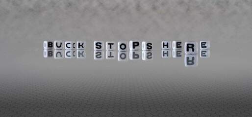 buck stops here word or concept represented by black and white letter cubes on a grey horizon...