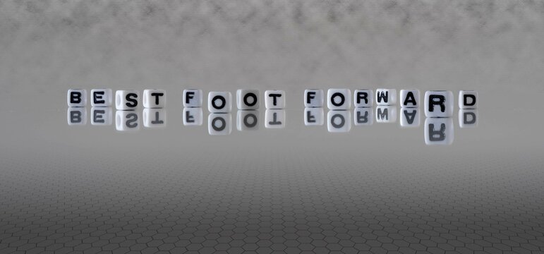 best foot forward word or concept represented by black and white letter cubes on a grey horizon background stretching to infinity