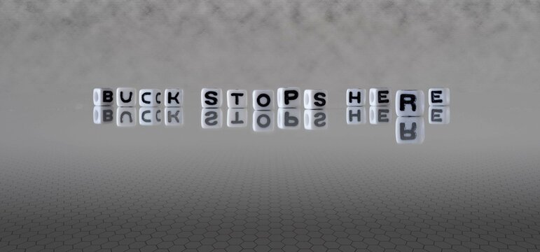 buck stops here word or concept represented by black and white letter cubes on a grey horizon background stretching to infinity