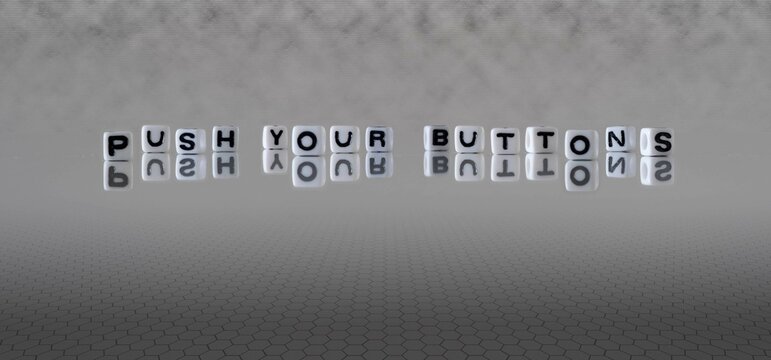 push your buttons word or concept represented by black and white letter cubes on a grey horizon background stretching to infinity