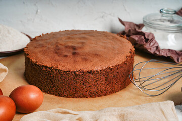 Homemade round chocolate sponge cake or chiffon cake on baking paper so soft and delicious with...