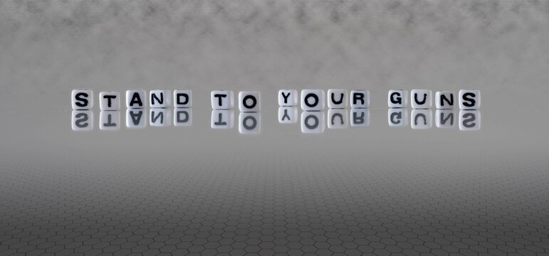 stand to your guns word or concept represented by black and white letter cubes on a grey horizon background stretching to infinity