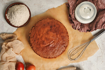 Homemade round chocolate sponge cake or chiffon cake on baking paper so soft and delicious with...