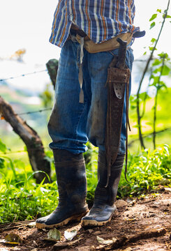 Farmer in rubber boots  in Costa Rica with Machete 