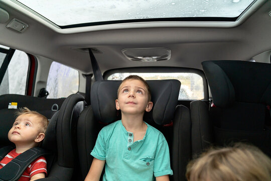 Cute brothers sitting in car seat in modern automobile