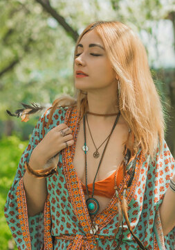 Ethnic hippie woman posing in boho style clothes at nature. Outdoor fashion. Concept of boho style and etno