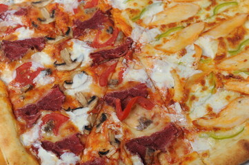 Freshly baked pizza with various herbs on a wooden stand.