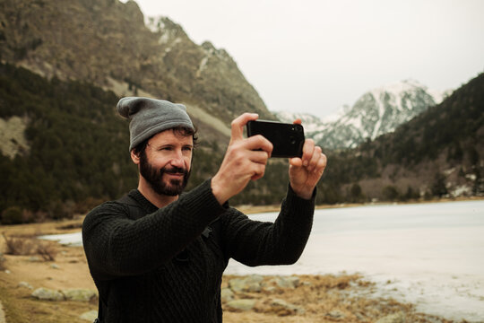 hiker man taking photos with phone outdoors