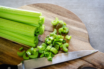 Celery stalks, stems on wooden cutting board, close up. Healthy eating, healthy lifestyle concept.