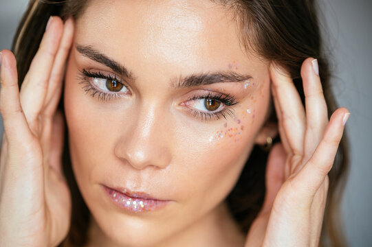 Young woman model with glitter on face
